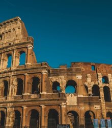 Stunning view of the ancient Roman Colosseum in Rome, Italy, captured at sunset showcasing its historic arches.